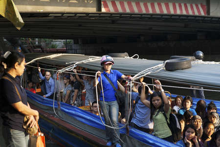 Bangkok Thailand - February 24, 2011: Fully packed express boat arriving a pier along the canal Khlong Saen Saeb (Saep).のeditorial素材
