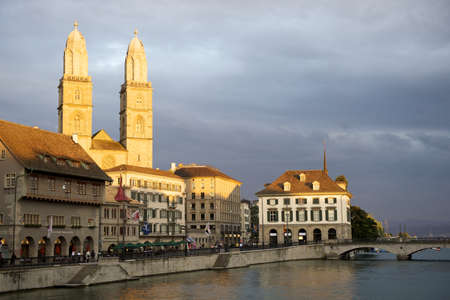 Zurich, Switzerland - June 6, 2011: Zurich's landmark the Grossmunster and the Minster Bridge with old town houses along the river Limmat.のeditorial素材
