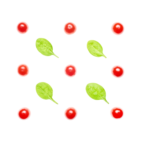 Flatlay of ripe cherry tomatoes and fresh spinach leaves isolated on white; creative arrangementの写真素材