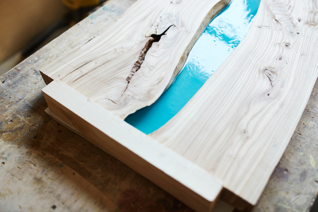 From above of composed wooden planks of table with place for epoxy resin on desk in joineryの写真素材