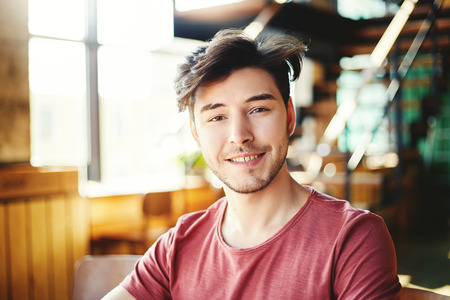 Portrait of handsome Hispanic man with stubble beard looking at camera and smilingの写真素材