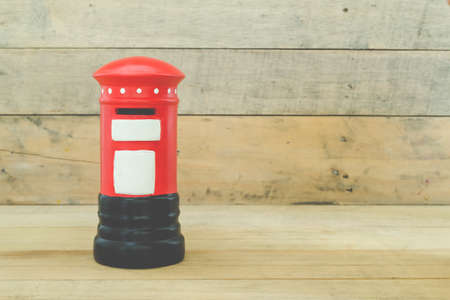 Small red post box on wood backgroundの写真素材