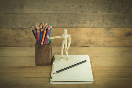 Robot standing holding a pencil on notebook,retro vintage styleの写真素材