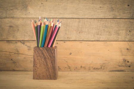 group of color pencils in a wood cup ,retro vintage style top view.の写真素材
