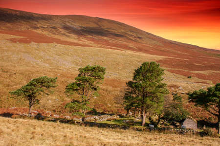 Sunset over deserted farm in Comeragh Mountains with colorful clouds .County Waterford, Ireland.の写真素材