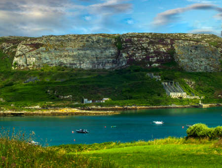Rocky hills overlookin a tranquil bay on Atlantic shore of West Cork, Ireland.の写真素材