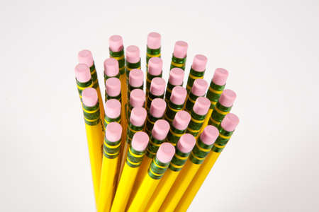 A bunch of erasers on yellow #2 pencils against a white background.の写真素材