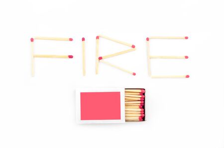 Text fire made of matches including a rose matchbox on whiteの写真素材