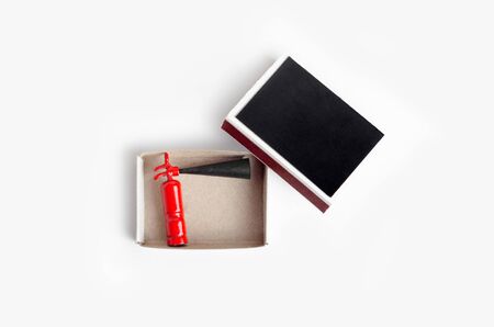 Small size fire extinguisher inside an opened match box, top view on whiteの写真素材