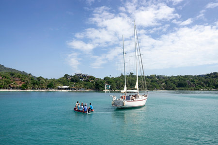 Koh Phangan, Thailand, December 10, 2019 - A group of tourists has changed the yacht for an inflatable boat and is heading on an excursion to the island.のeditorial素材