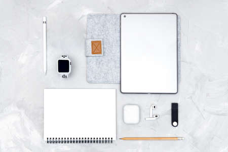 Minimal designer workplace with office accessories and trendy gadgets: paper notebook, smartwatch,...