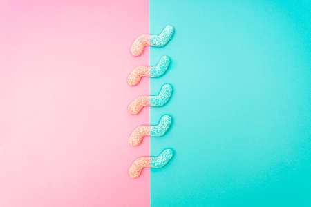 Colored z-shaped jelly worms on a contrast pink and blue backgroundの写真素材