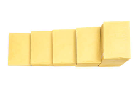 Top view of five stacks of yellow mail envelopes arranged in line in descending order imitating stairs isolated on whiteの写真素材