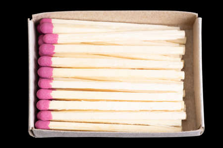 Matchsticks in a matchbox isolated on black. Top view, closeup.