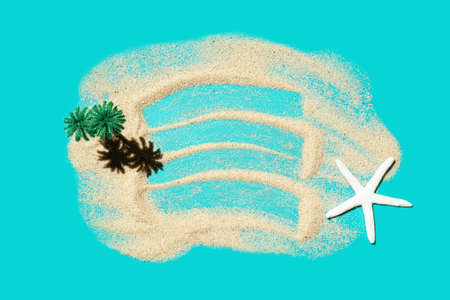 Miniature tropical island made of sand, toy palms and a sea star on a turquoise background. Creative paradise vacation concept.の写真素材