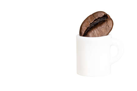 Miniature coffee cup with a coffee bean isolated on white. Sense of proportion.の写真素材