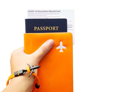 Passport with a vaccination record card and documents organizer in hand isolated on white. Pandemic...