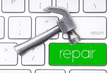Small steel hammer lies on the keyboard, which has a green key labeled REPAIR. Hardware service...