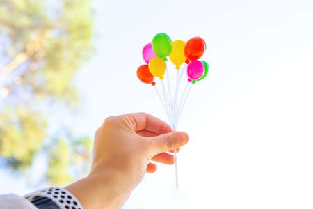Bunch of colorful tiny plastic balloons in hand