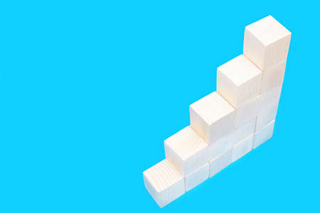 Stairs made of ascending wooden toy blocks isolated on blue.の写真素材