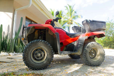 All-terrain vehicle parked by a house. The most popular form of transportation in Costa Rica.の写真素材