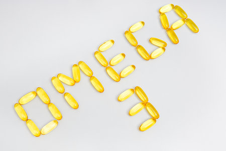 Translucent fish oil capsules arranged into a lettering OMEGA 3 isolated on white. The power of fish concept.の写真素材