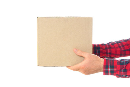 Crop view of male hands in red checkered shirt holding a cardboard box isolated on white. Christmas holidays delivery concept.の写真素材