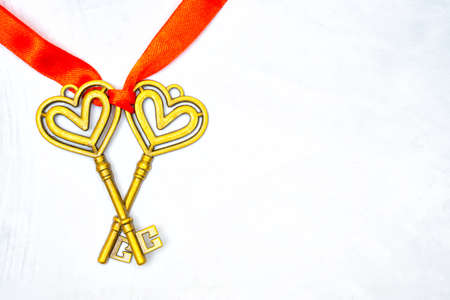 Two vintage keys tied with a red ribbon on a neutral background with copy space. Healthy marriage...