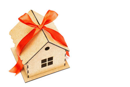 Toy house with a red ribbon bow on top isolated on white background. Mortgage loan concept.の写真素材