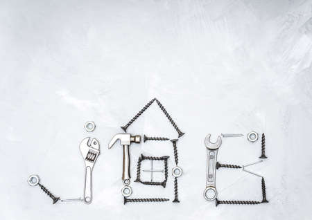 Text JOB and a house outline made from miniature steel copies of hand tools, screws, nails and nuts...