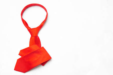 Tied red necktie folded on a neutral background with copy space. Creative business occupation concept.の写真素材