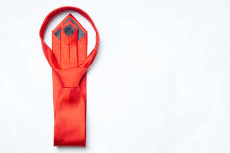 Stylish red necktie folded on a neutral background with copy spaceの写真素材
