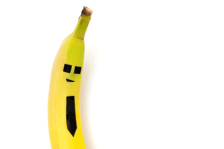 Stylish banana character wearing a black tie isolated on white. Creative security concept.の写真素材