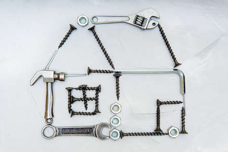 Dimensional house shape made from miniature hand copies of essential hand tools, screws, nails and...