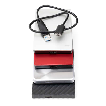 Selection of various portable hard disk drives with a connection cable isolated on white background.