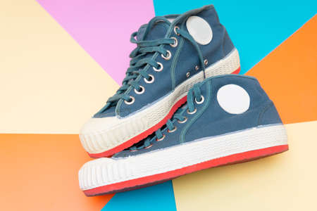 Pair of old-fashioned canvas trainers on a vivid retro style abstract background.の写真素材