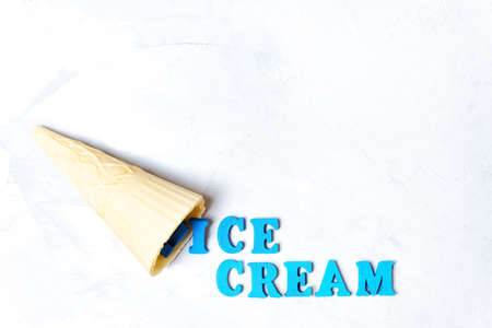 Waffle cone and ICE CREAM lettering on a concrete background with copy space.の写真素材
