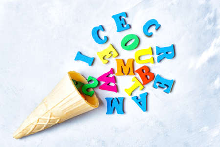 Waffle cone and multicolored wooden letters arranged into an ice cream shape with lettering....