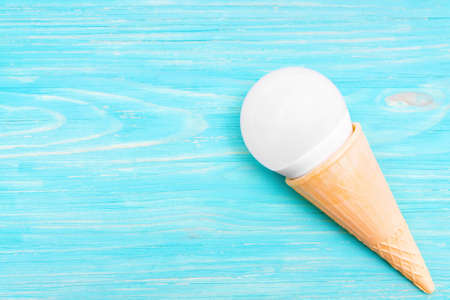 LED light bulb in a waffle ice cream cone on a blue wooden background with copy space.の写真素材