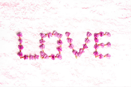 Word LOVE floral shape made from pink acacia flowers. Romantic decoration background.の写真素材