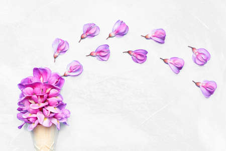 Delicate spring floral background made from pink acacia flowers in a waffle cone with copy space.