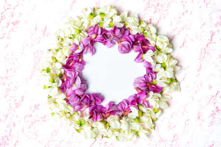 Floral circle frame made from pink and white acacia flowers with copy space.の写真素材
