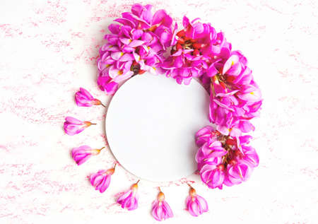 Springtime floral background made from pink acacia flowers and petals, copy space.
