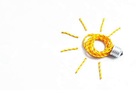 Glowing lightbulb symbol made from a clothes drying rope and a bulb base isolated on white...