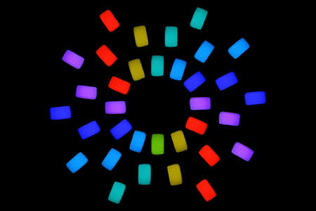 Neon glow sun shape made from three rows of jelly cubes isolated on black background. Bright party...