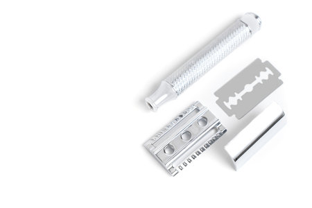 Traditional chrome-plated closed-comb safety razor disassembled on white background.の写真素材