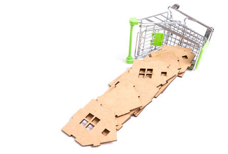 Overturned miniature push trolley and wooden toy house parts isolated on white background....