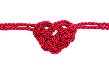 Heartbeat symbol made from braided red cord isolated on white background. Creative healthcare concept.の写真素材
