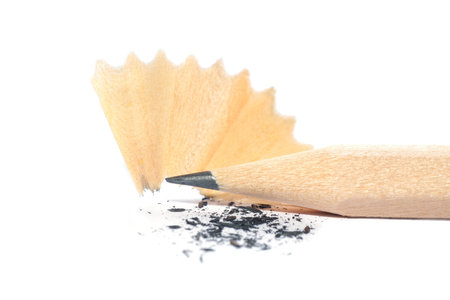 Graphite pencil tip close-up with sharpening shavings on white backgroundの写真素材
