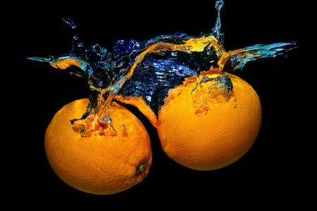 Two fresh oranges in water splashes isolated on black background.の写真素材